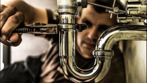 plumber doing maintenance work on a pipe